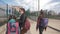 A Mother and two daughters in a protective anti-virus mask walk along the street in an isolated area.