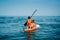 Mother with two daughters stand up on a paddle board