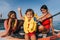 Mother with two daughters stand up on a paddle board