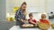 Mother and two kids making pizza with basil