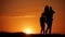 Mother and two kids silhouettes at sunset. Concept of friendly family.