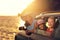 Mother with two kids travel by car on summer vacation, sunset