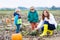 Mother and two little sons having fun on pumpkin patch.