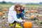 Mother and two little sons having fun on pumpkin patch.