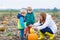 Mother and two little sons having fun on pumpkin patch.