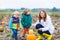 Mother and two little sons having fun on pumpkin patch.