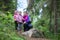 Mother with two small twins daughters walking in forest