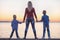 Mother and two sons walk on the promenade and watch the sunset