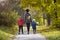Mother and two sons walking in the autumn forest. Back viewMother and two sons walking in the autumn forest. Back view