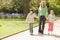 Mother and two young children walking on path