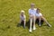 Mother and two young sons sitting on grass