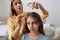 Mother using nit comb and spray on hair at home. Anti lice treatment