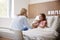 Mother Visiting Daughter Lying In Bed In Hospital Ward