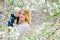 Mother walking with her baby son in garden of blooming magnolias