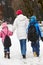 Mother Walking Two Children To School In Snow