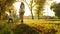 Mother walks with child in autumn park at sunset. child is walking along path in beautiful rays of the sun