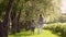 Mother walks with her daughter along the avenue of apple trees. The little girl is holding her mother by the hand. Child