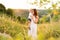 Mother walks with her son in arms in a picturesque summer field.