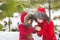 Mother warms hands of little daughter in snow in park