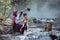 Mother was showering for a baby daughter. At a stream in a rural area of Thailand