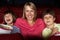 Mother Watching Film In Cinema With Two Children