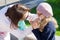 Mother wipes daughter`s mouth with a tissue paper.