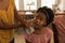 Mother wiping daughter mouth with napkin after meal on dining table