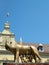 Mother wolf with Remus and Romulus and clear blue sky.