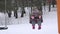 Mother woman and baby girl swing on winter playground. Snow blizzard. 4K