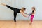 mother yoga instructor and daughter do balance exercises with elastic band