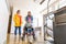 Mother with a young child living with cerebral palsy using electric wheelchair lift to access public building.