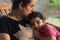 Mother and young child sit on rock chair and enjoying together at outdoor balcony