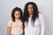 Mother and young daughter standing over white background in shock face, looking skeptical and sarcastic, surprised with open mouth