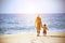 Mother and young son walk beach