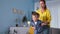 motherhood, a caring female parent helps her son jump on a trampoline during home weekends