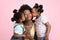 Motherhood and family concept. Lovely cute two little African girls kids in summer outfits, having fun and kissing their