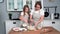 motherhood, loving female parent cooks dough with her daughter and pours milk into a bowl while standing at a table in