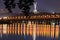 Motherland Monument at the top of the hill in tree leaves border. Natural frame. Autumn night panorama of Dnipro River