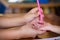 Mothers or adults use a soft pink magic pen to write onto the skin of the daughters hands or young children gently.