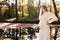 Mothers day. Beautiful young pregnant woman in white tight knit dress with little belly relaxing outdoors by the pond