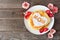 Mothers Day breakfast pancakes with heart shape and MOM letters, top view on rustic wood