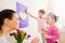 Mothers day, girls giving flowers and card to their mum