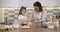 Mothers day, mother and daughter child together at home kitchen preparing cookies, kneading dough in bowl