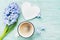 Mothers Day spring greeting background with hyacinth flowers, cup of coffee and white wooden heart top view. Morning breakfast.