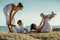 Mothers and their sons are doing yoga exercises at the seashore