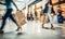 motion blur of people with shopping bags in a busy shopping mall. retail sale and discount