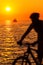 Motion blur silhouette of male biker by sea in sunset