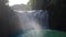 Motion blur of a waterfall with water mist in the foreground. The center have very strong over exposure natural sunlight