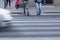 Motion blurred scene of pedestrians crossing the street
