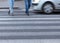 Motion blurred scene of pedestrians legs crossing the street